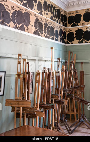 Ein Stapel von staffeleien in den Clubraum des Londoner Sketch Club. Die Silhouetten der letzten Mitglieder zieren die Wand über Stockfoto