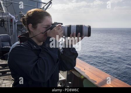 180703-N-DZ 642-0020 ATLANTIK (3. Juli 2018) Cryptologic Techniker (Sammlung) 2. Klasse Angelina Grambo nimmt Informationsbeschaffung Fotos vom Hafen Brücke Flügel an Bord der geführte-missile Cruiser USS Normandie (CG60), 3. Juli 2018. Die Normandie ist derzeit als Teil der Harry S. Truman Carrier Strike Group bereitgestellt. Mit Harry S. Truman als Flaggschiff, Bereitstellung Streik Vermögenswerte des Konzerns gehören Personal, Schiffe und Flugzeuge von Carrier Strike Group (CSG) 8, Destroyer Squadron (DESRON) 28 und Carrier Air Wing (Cvw) 1 sowie die Sachsen-Klasse deutsche Fregatte FGS Hessen (F221). (U.S. Marine Stockfoto