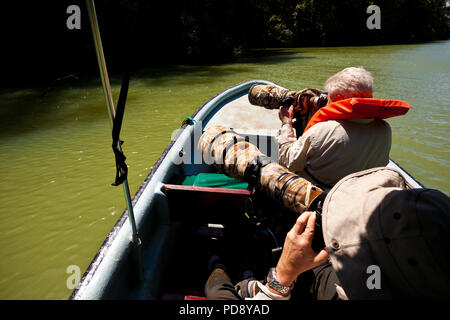 Zwei Naturfotografen mit großen Teleobjektiven in einem Boot in einem Der Sidearms der Gatun See, Republik Panama. Stockfoto