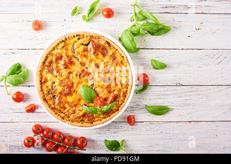 Hausgemachte Quiche Lorraine mit Huhn, Pilzen und Käse auf weißem Holz- Hintergrund. Französische Küche Stockfoto