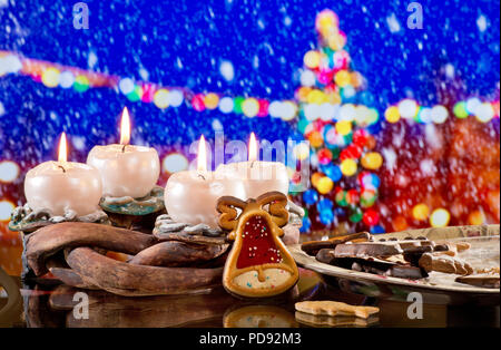 Adventskranz mit brennenden Kerzen vor dem Weihnachtsbaum Stockfoto