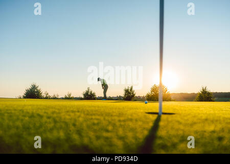 Silhouette eines männlichen Spieler schlagen eine lange Schuß auf dem Golfplatz Stockfoto