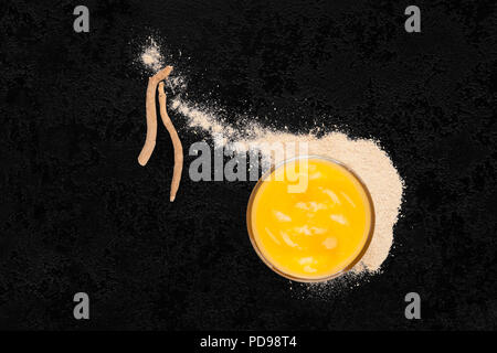 Ashwagandha Ergänzung Pulver, Pudding und Wurzel von oben. Stockfoto