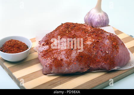 Schweinesteaks mit Fett. Fleisch ist auf Holzbrett mit Gewürze wie Pfeffer und grünen Frühlingszwiebeln. Bereit für das Kochen. Selektive konzentrieren. Stockfoto