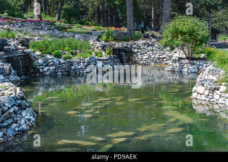 Ein Teich mit Steinmauern in Banff Garten. Stockfoto