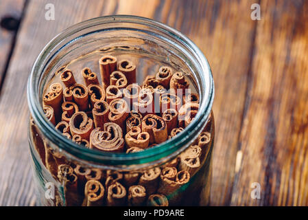 Jar von Zimtstangen auf hölzernen Tisch. Kopieren Sie Platz auf der rechten Seite. Stockfoto