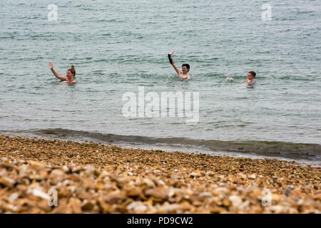 Drei Menschen schwimmen im Meer Stockfoto