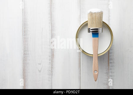 Pinsel und kann auf weiße Holztisch Stockfoto