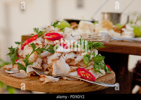 Ein leckeres Stück Schweinefleisch Speck mit Gewürzen, mit Petersilie auf ein holzbrett eingerichtet. Hochzeitstisch Stockfoto