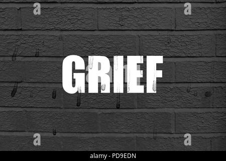Wort "Trauer" auf dem schwarzen Hintergrund mit Spuren von Tränen auf den weißen Buchstaben und der Hintergrund Stockfoto