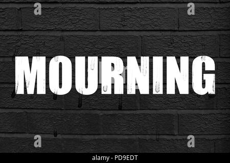 Wort 'Mourning' an der schwarzen Wand Hintergrund mit Spuren von Tränen auf den weißen Buchstaben und der Hintergrund Stockfoto