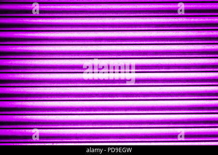 Nahaufnahme der welligen Aluminium Metall oberfläche Hintergrund in lila, Ultra Violet, fuchsia Farbe im Sonnenlicht. Stockfoto