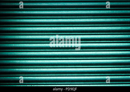 Nahaufnahme der welligen Aluminium Metall oberfläche Hintergrund in Grün, Türkis, Petrol Farbe im Sonnenlicht. Stockfoto