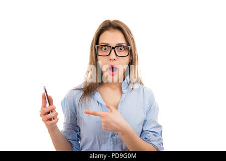 Casual tausendjährigen Mädchen mit blauem Hemd und geschockt und beim Lesen von Nachrichten in Smartphone auf weißem Hintergrund erstaunt. Stockfoto