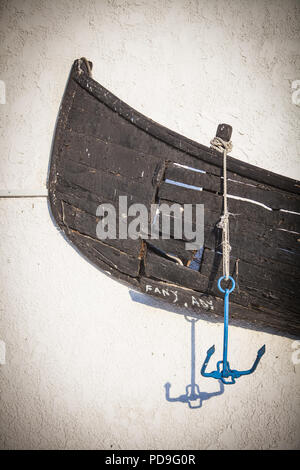 Eine alte verlassene Holz- Boot auf einer Wand angezeigt. Stockfoto