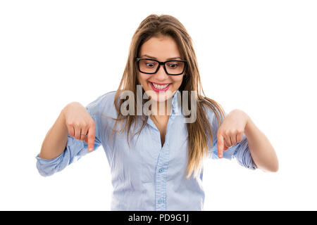 Junge lächelnde aufgeregt Frau in Gläsern und Shirt nach unten zeigt mit Fingern auf der Suche glücklich isoliert auf weißem Hintergrund Stockfoto