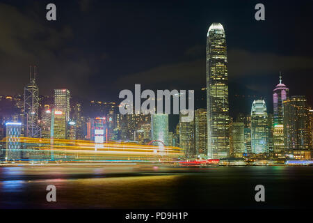 Leichte Spuren von einem vorbeifahrenden Boot Überfahrt Victoria Harbour Hong Kong in der Abenddämmerung. Stockfoto