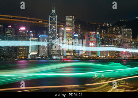 Leichte Spuren von einem vorbeifahrenden Boot Überfahrt Victoria Harbour Hong Kong bei Nacht. Stockfoto