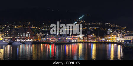 Bergen, Norwegen - 17. November 2017: Nacht Panorama der alten Bergen. Der Blick auf den Hafen mit bunten Beleuchtung und Reflektionen im Meerwasser Stockfoto