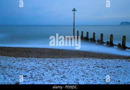 Groyne Holz in der Nähe der Stadt von Seaton in Devon. Verschwommenes Wellen im Meer und Schnee auf den Kiesstrand an der Jurassic Coast. Stockfoto