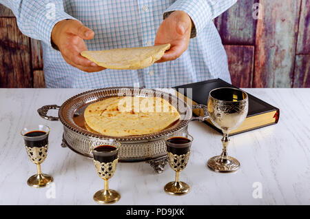 Blick von oben auf die Heilige Kommunion auf hölzernen Tisch in der Kirche. Schale aus Glas mit Rotwein, Gebet für Brot Stockfoto