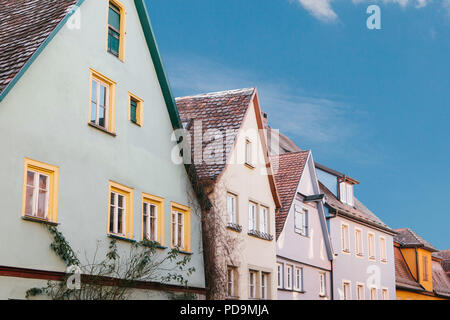 Bunte Häuser mit vielen Fenstern gegen den blauen Himmel in Rothenburg o.d. Tauber in Deutschland. Stockfoto