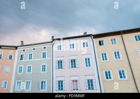 Bunte Häuser mit vielen Fenstern vor dem Hintergrund der untergehenden Sonne am Abend. Stockfoto