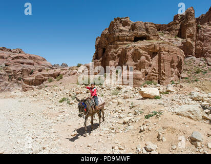 Kleiner Junge auf einem Esel, hinter Felsengräber, Petra, Jordanien Stockfoto