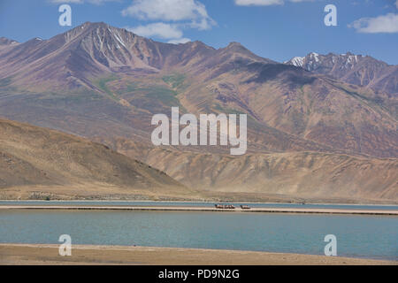 Kamele auf einer Sandbank am Emerald Lake Yashilkul, Pamir Highway, Tadschikistan. Stockfoto