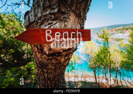 Assos Dorf im Morgenlicht, Kefalonia. Griechenland. Strand Holz- Pfeil auf einer Kiefer Richtung zeigen zu kleinen versteckten Strand Stockfoto