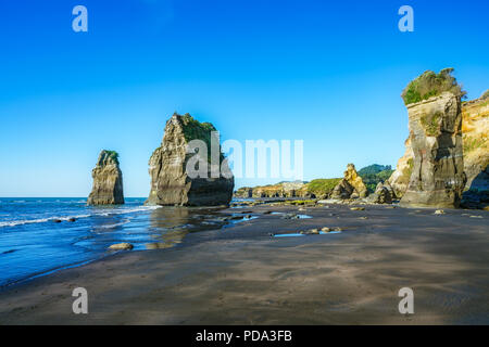 Blaues Wasser, goldenen Felsen und Sand. Am Strand, 3 Schwestern und Elephant Rock, Neuseeland Stockfoto