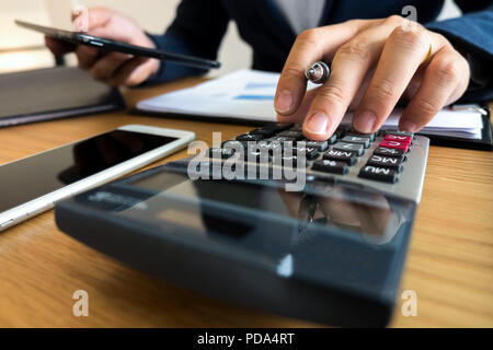 Unternehmer berechnen sie die Einnahmen aus dem Export Geschäft auf dem Holz Tisch. Business Konzept. Stockfoto