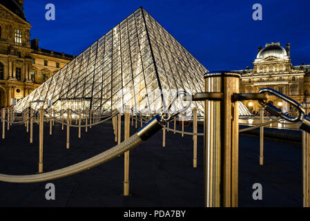 PARIS, Frankreich, 28. JULI 2018: Eingang des Louvre Museum mit seinen golden leuchtenden Barrieren. Stockfoto