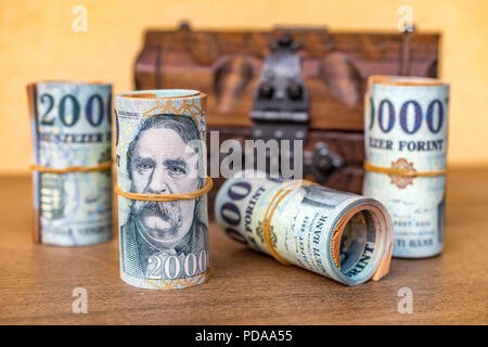 Bis 20000 Forint Banknoten mit einem geschlossenen vintage Holzkiste im Hintergrund gerollt Stockfoto