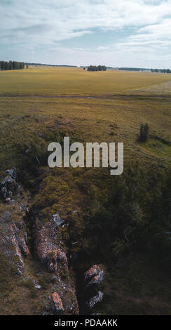 Antenne Panoramablick auf karsthöhle Eingang, ziemlich selten in der Steppe Zone, Golden Meadow auf Hintergrund, Russland Stockfoto