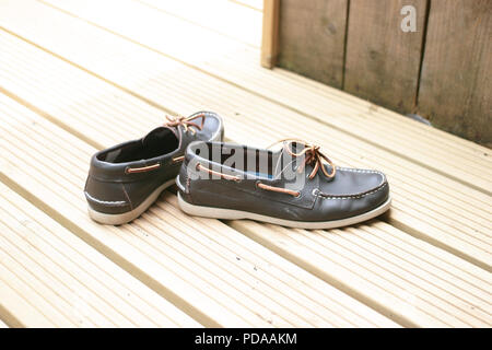 Ein Paar Schuhe aus Leder für Männer, auf der Holzterrasse im Garten. Stockfoto