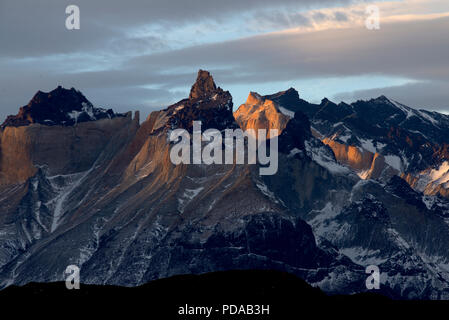 Mt Almirante Nieto mit den ersten Strahlen der Sonne schlagen Die oben, in den Gewässern des Laguna Larga, Torres del Paine Nationalpark, Chile wider. Stockfoto
