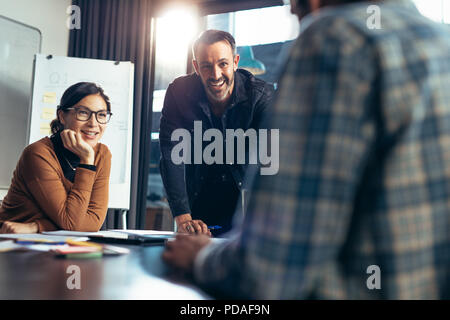 Lächelnd business Menschen Aufmerksamkeit zu Kollegen Diskussion im Konferenzraum. Fröhlicher und positiver Business Team Tagung im Konferenzraum. Stockfoto