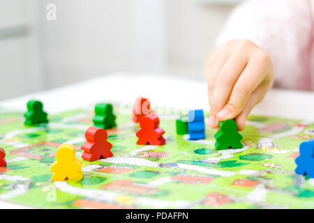 Brettspiel und Kinder Freizeit Konzept - grüne Menschen Abbildung in der Hand des Kindes. rot, blau, grün Holzspäne in Kinder spielen Stockfoto