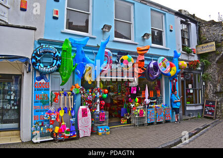 Eine farbige Darstellung der Ware an einem traditionellen Geschenk Shop in Tenby, Wales. Die Bush Inn, einem der Tenby kleiner Kneipen ist nebenan. Stockfoto