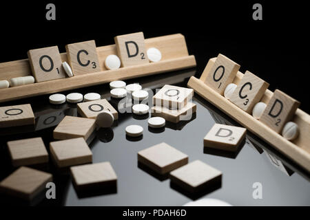 OCD Konzept in Scrabble Text mit pharmazeutischen Medikamente auf einem schwarzen Tabelle geschrieben. Zwangsstörungen und Verhalten Stockfoto