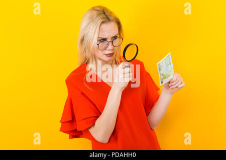 Blonde Frau im Kleid mit Lupe Stockfoto