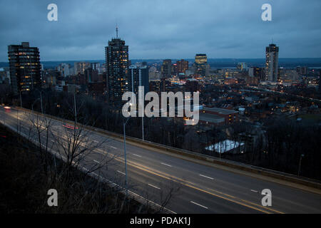 Stadt hi steigt in der Abenddämmerung. Stadt Panorama in der Dämmerung mit Motion verschwommen Autos. Stockfoto