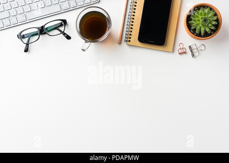 Business-Konzept - Draufsicht des weißen Desktophintergrund mit Notebook, Kaffee, Smartphone, Kakteen und Clip für Modell-design Stockfoto