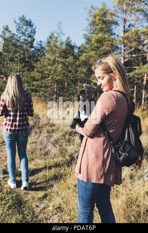 Junge blonde Frau mit französischen buldog Welpen und genießen Sie in sonniger Tag. Stockfoto