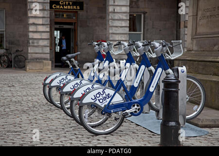 Ihr Fahrrad in einem Rack docking station außerhalb der Stadt Kammern Büros, Edinburgh, High Street, Royal Mile, Schottland, UK mieten Stockfoto