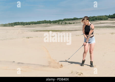 Frau schlägt mit einem Golf Club Stockfoto