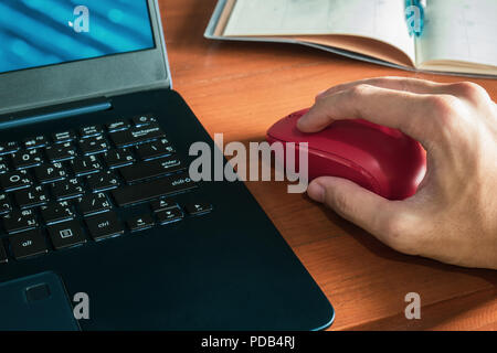 Männliche hand mit Maus mit Laptop Stockfoto