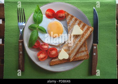 Frühstück mit Eiern, Tomaten und frisch getoastetes Toast. Stockfoto