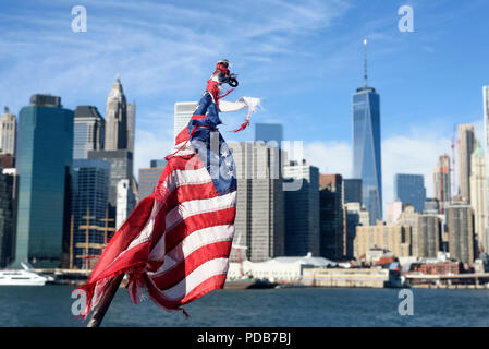 29-10-15, New York, USA. Ein unscharf Manhattan aus Brooklyn gesehen, über den East River, mit einem abgenutzten amerikanische Flagge im Fokus im Vordergrund. Ph Stockfoto